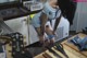 A woman in a blue dress is bending over a kitchen counter.