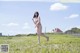 A woman in a pink bikini running across a field.