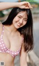 A woman in a pink polka dot bikini posing for a picture.