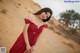 A woman in a red dress standing in the desert.