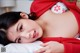 A woman laying on top of a bed in a red sweater.