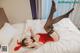 A woman in a red lingerie laying on a bed.